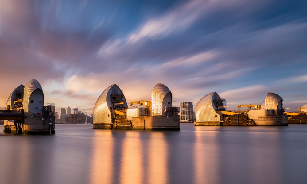 The Thames Flood Barriers in East London with Canary Wharf in the distance and a dramatic sunset, January 2018